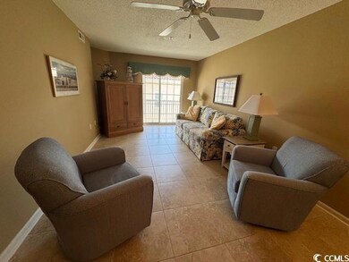 Living area with a textured ceiling, a ceiling fan