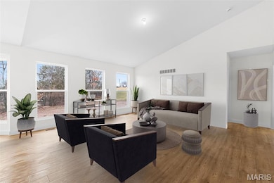Living area featuring light wood finished floors and high vaulted ceiling