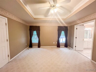 Empty room featuring a tray ceiling, crown molding