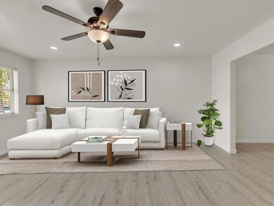 Living room featuring ceiling fan and light hardwo