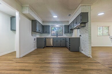 Kitchen featuring backsplash, wood-type flooring, 