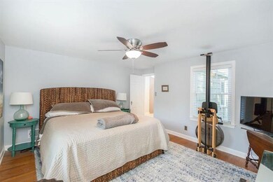 Bedroom with hardwood floors and ceiling fan.