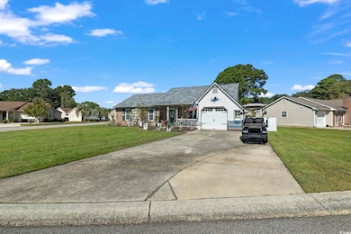 View of front of house with concrete driveway, a front lawn, and an attached garage
