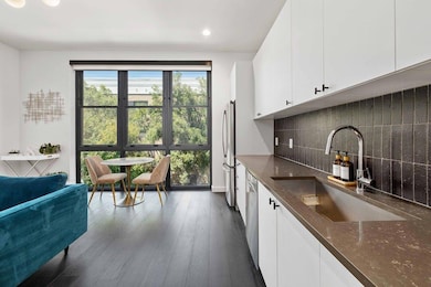 Kitchen with white cabinetry, dark stone counters