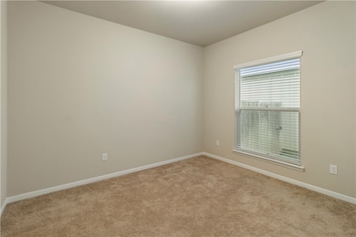 Carpeted spare room with baseboards