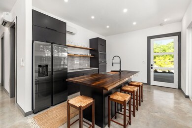 Kitchen with backsplash, concrete floors, applian