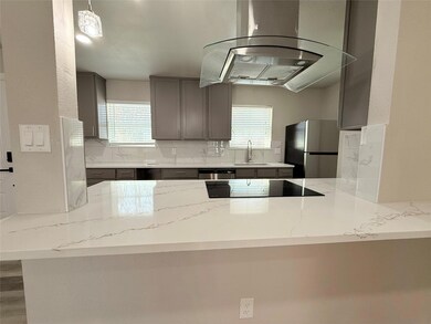 Kitchen with island range hood, decorative backspl