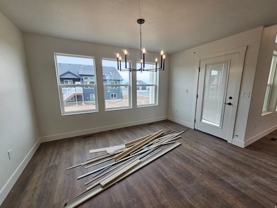 Unfurnished dining area with a chandelier and dark wood finished floors
