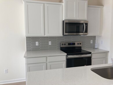 Kitchen with white cabinets, light stone counterto