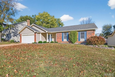 Ranch-style house with brick siding, a front yard, an attached garage, a chimney, and concrete driveway
