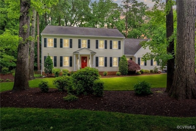 Colonial-style house with a chimney, a front yard,