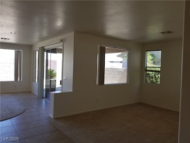 Empty room featuring a textured ceiling, visible v