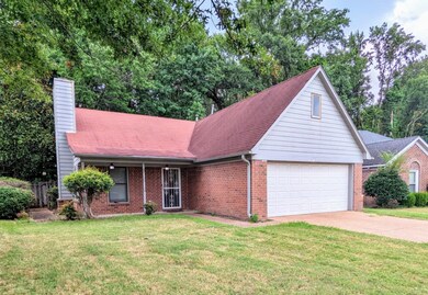 View of front facade featuring a garage and a front yard