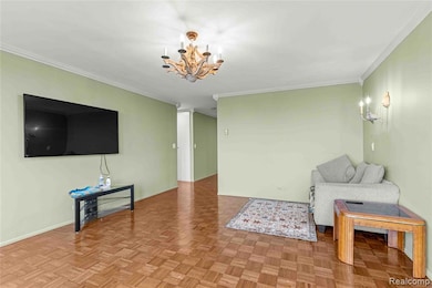Living room with crown molding and a chandelier