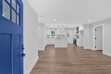 Entryway featuring baseboards, light wood-type flooring, and recessed lighting