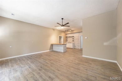 Unfurnished living room featuring a ceiling fan and light wood-style floors