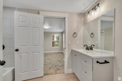 Full bath with vanity and baseboards