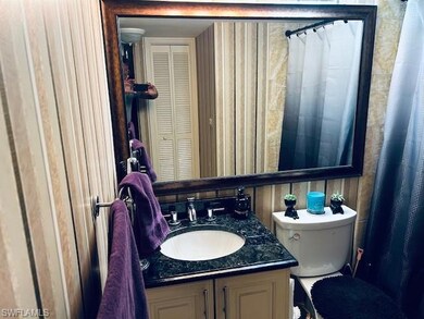Full bath with vanity, wooden walls, and toilet