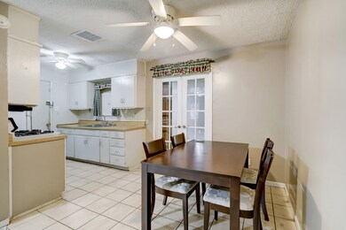 The breakfast area shares common space with the kitchen and living room. The french doors behind the breakfast area open to a secondary bedroom of the home. The largest of the four.