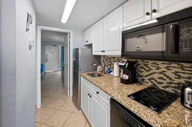 Kitchen featuring tasteful backsplash, white cabin