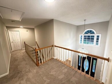 Corridor with an upstairs landing, carpet, and a textured ceiling