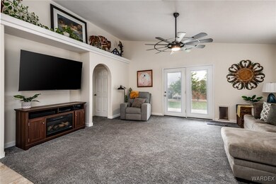 Living room with arched walkways, a ceiling fan, c