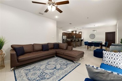Living room with ceiling fan and light tile patterned floors