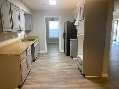 Kitchen with a sink, baseboards, healthy amount of natural light, and light wood-style flooring