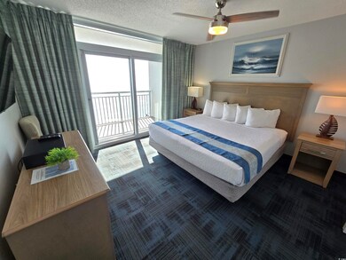 Carpeted bedroom with access to oceanfront balcony