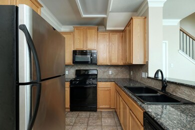 Kitchen with black appliances, a sink, backsplash