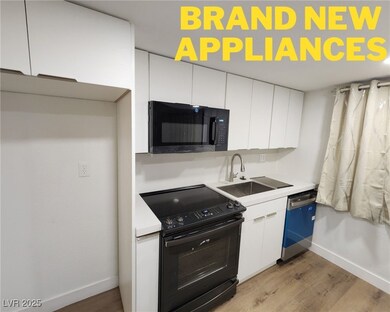 Kitchen featuring black appliances, white cabinets