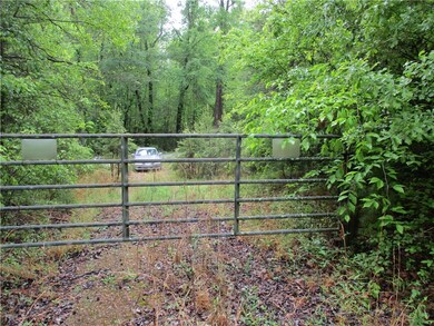behind gate to gravel road entrance