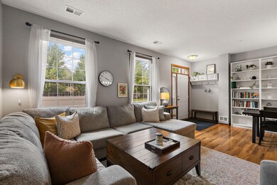 The main floor living room flows with the open concept design into the dining area and kitchen with a view of the front patio.
