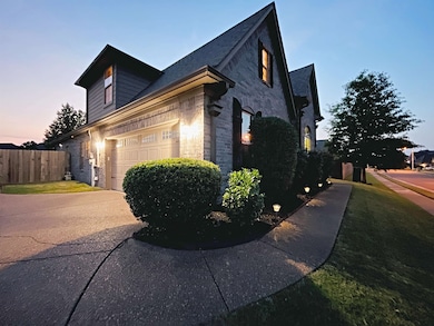 View of side of property with concrete driveway, brick siding, and an attached garage