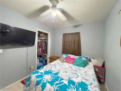 Tiled bedroom featuring ceiling fan, a closet, and