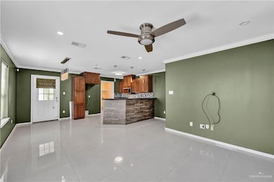 Unfurnished living room with light tile patterned floors, ceiling fan, baseboards, ornamental molding, and visible vents