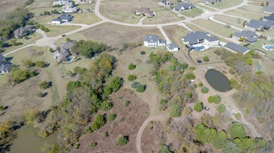 Aerial view of property and surrounding area featuring nearby suburban area and a nearby body of water