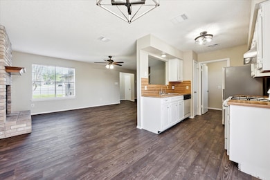 Kitchen featuring white appliances, a sink, open 