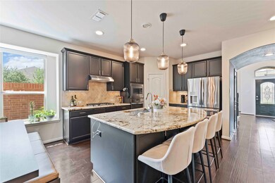 Rich cabinetry, under-cabinet lighting, and stone