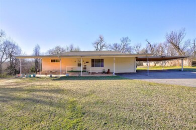 View of front of home with a front lawn, a carport