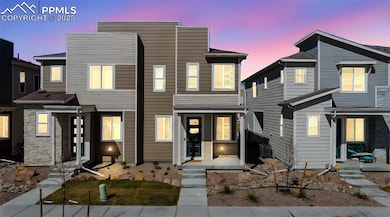 Front of modern townhome at dusk featuring beautif
