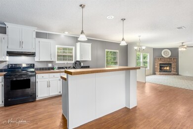 Kitchen featuring a fireplace, pendant lighting, b