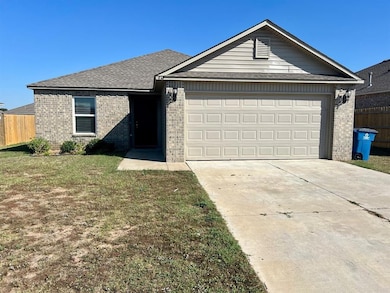 Single story home featuring brick siding, driveway, an attached garage, and roof with shingles