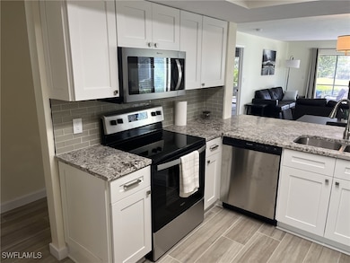Kitchen featuring sink, white cabinetry, appliance