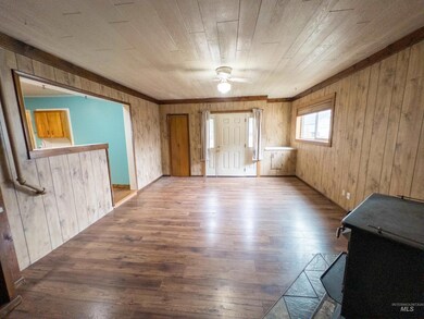 Unfurnished room with wood finished floors, wood walls, and a ceiling fan