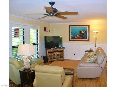 Living room with new laminate floor, fresh paint, crown molding, plantation shutters and new impact resistant windows!  (All windows and All doors are new and impact resistant).