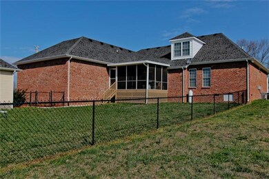 View of back of home with attached 2 car garage, fenced in area, covered/screened deck, and off to the left side sits the 24x24 oversized 2-car detached garage.