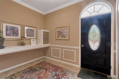 Entryway featuring crown molding and light tile patterned flooring