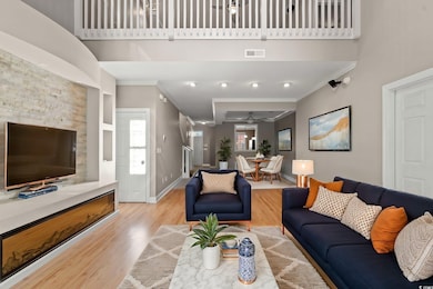 Living room featuring crown molding, wood finished floors, a ceiling fan, plenty of natural light, and baseboards