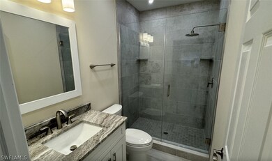 Bathroom with vanity, toilet, and a shower with do